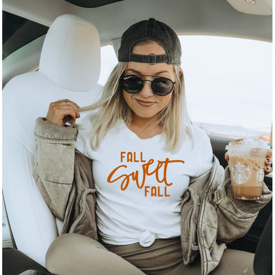 woman sitting in car wearing white t-shirt with orange lettering fall sweet fall