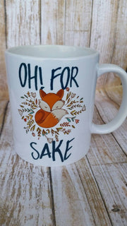 Oh for fox sake coffee mug featuring an orange fox with colorful small leaves around the fox
