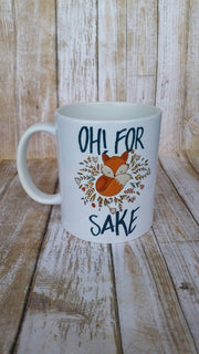 Oh for fox sake coffee mug featuring an orange fox with colorful small leaves around the fox