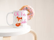 Oh, for fox sake in pink text featuring a orange and tan fox with sassy folded arms and eyes closed on a white ceramic coffee mug on table