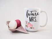 future mrs. in black text with pink and green floral bottom left printed on ceramic mug with macaroons to left of mug