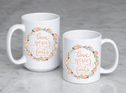 love never fails corinthians 13:8 quote in peach or olive with peach and olive floral wreath on ceramic mug on 2 mug sizes