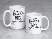 future mrs. with spot for personalizing in black text featuring 2 pink rings on white ceramic coffee mugs sized 11 oz and 15 oz