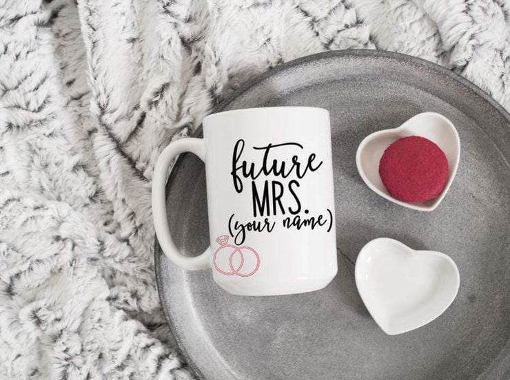 future mrs. with spot for personalizing in black text featuring 2 pink rings on white ceramic coffee mug