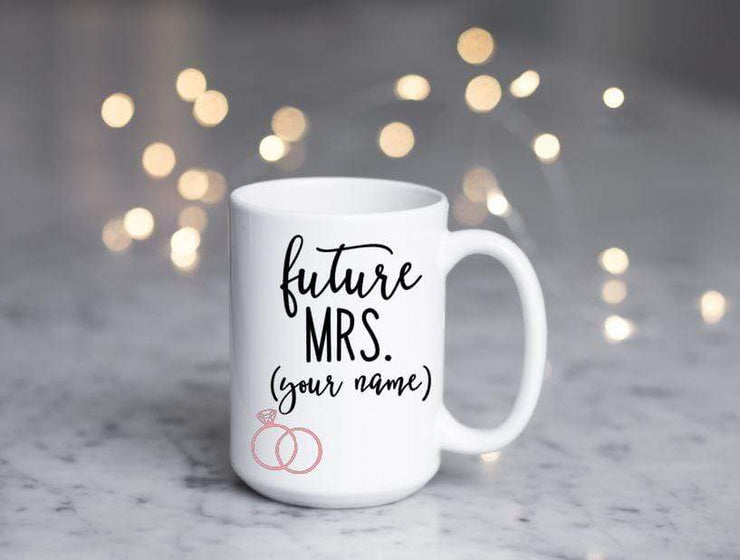 future mrs. with spot for personalizing in black text featuring 2 pink rings on white ceramic coffee mug with fake glitter popping out the top